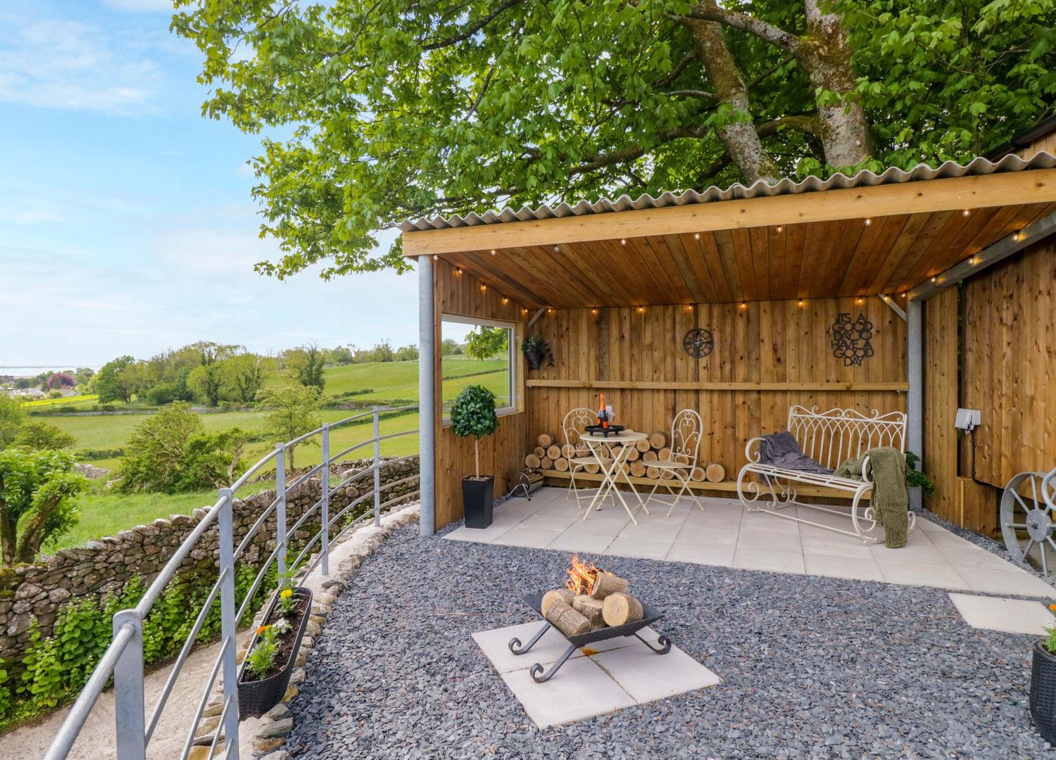 Sheltered seating and a fire pit beside the fields at Little Hut