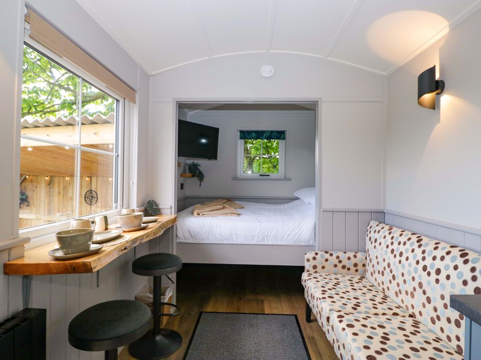 The double bed, breakfast bar and sofa inside Little Hut